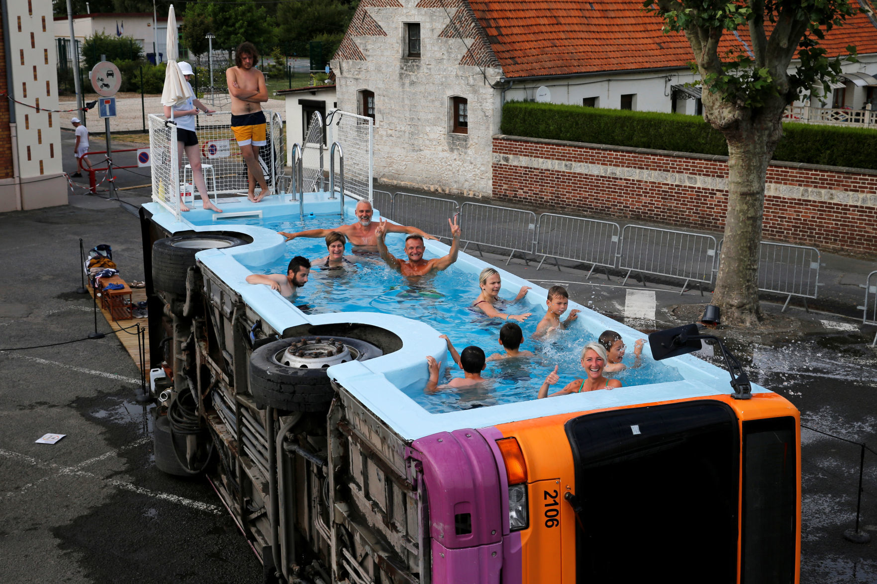 People bathe in a decommissioned city bus named "le bus piscine", an artwork by the French artist Benedetto Bufalino in Gosnay near Bethune